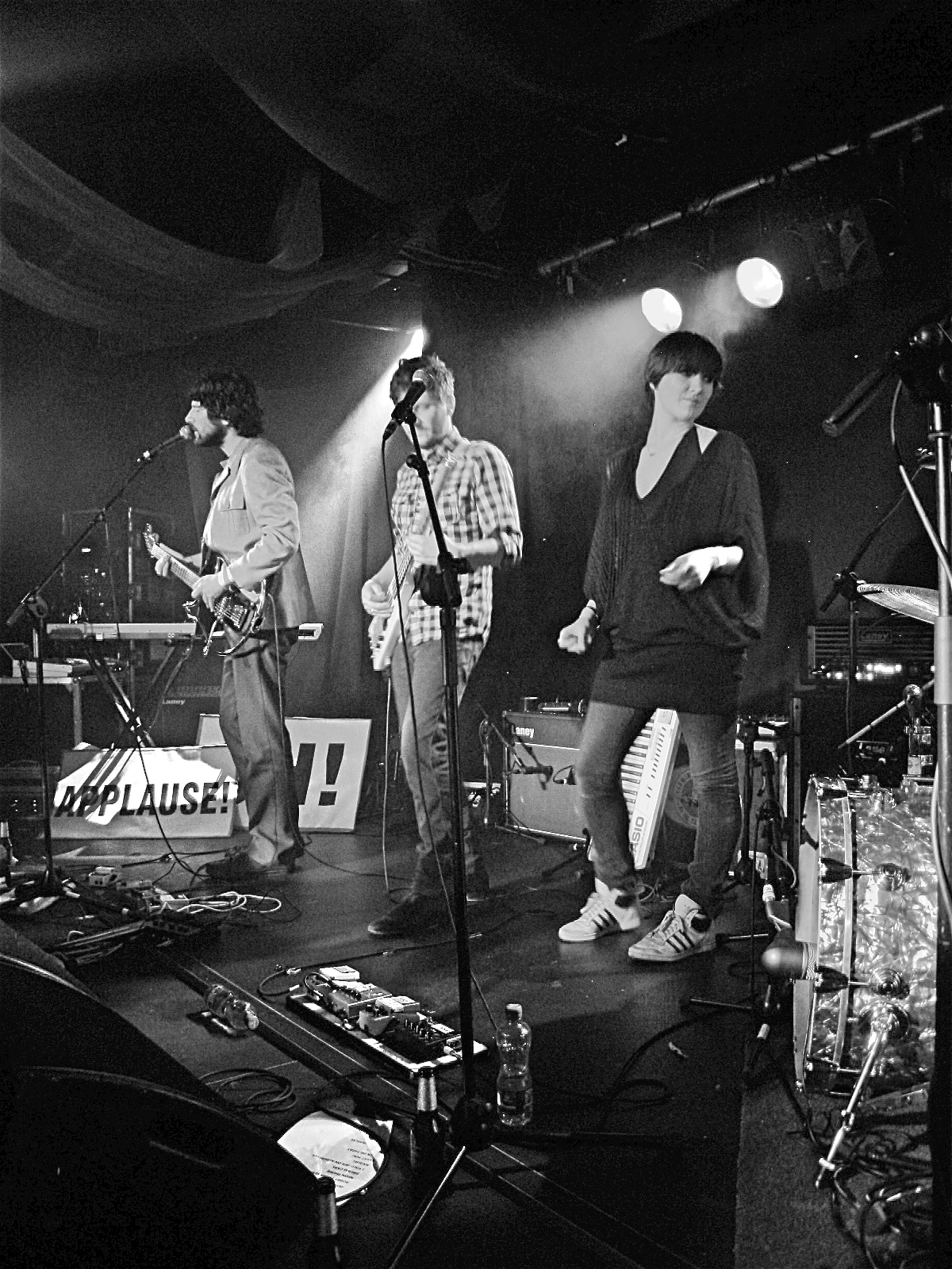 group of young people standing on stage with instruments