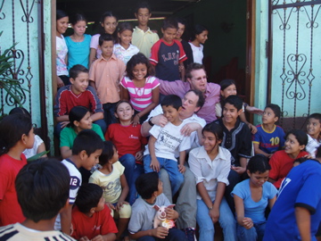 several young children are gathered around the teacher outside