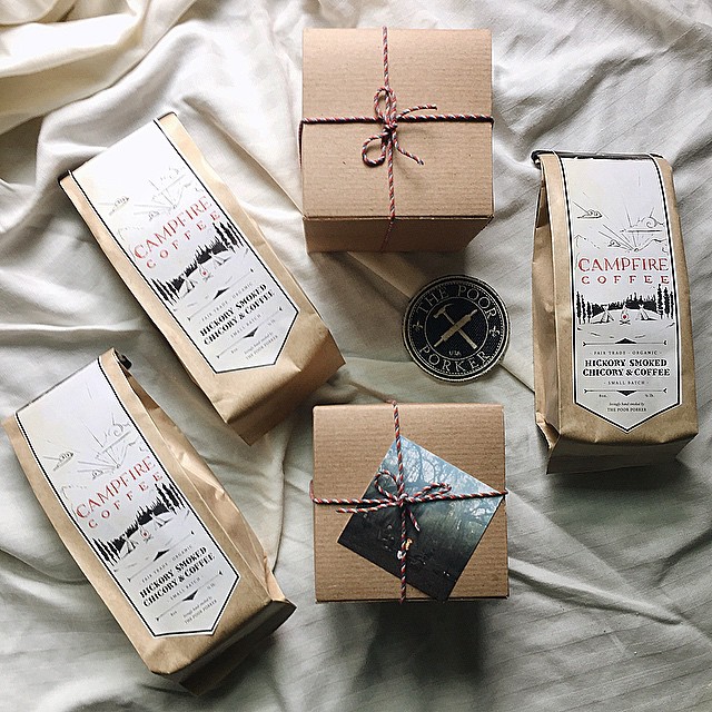 three wrapped gift boxes tied with brown twine on top of a white sheet