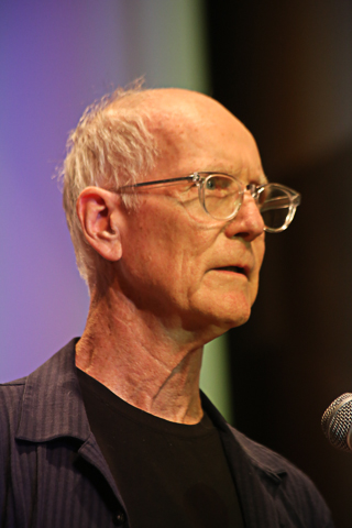 an older man with glasses and a microphone