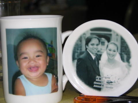 two plates on top of a wooden table with a picture on the front and side of a ceramic coffee mug