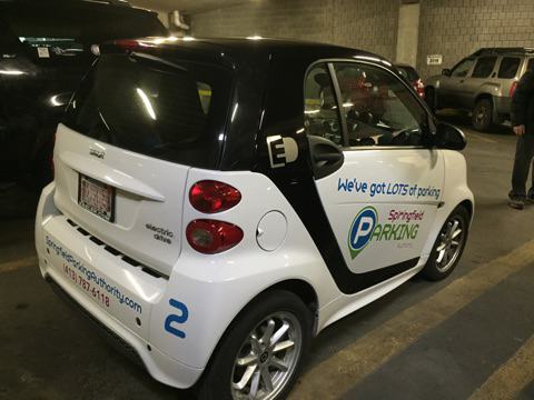 an electric smart car is parked in a parking garage