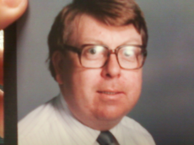 the man wearing glasses and a neck tie is holding his po