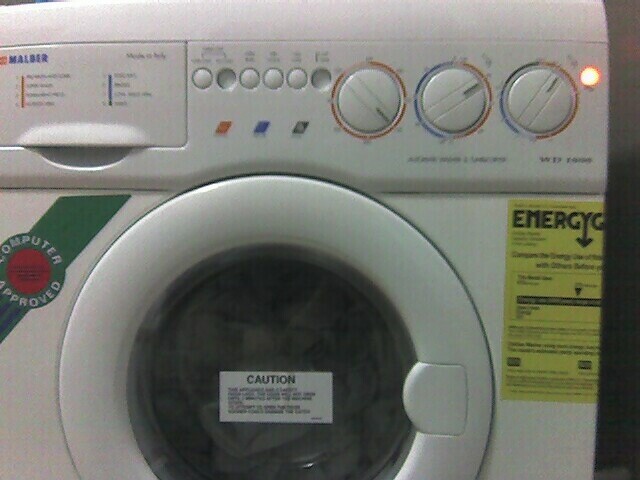 the front of a washer with a label reading caution