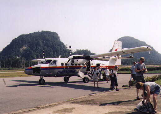 a small plane with people standing next to it