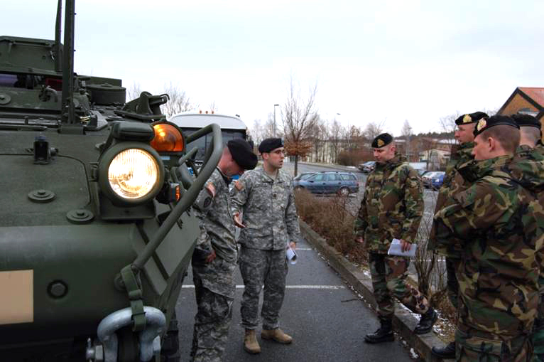 a group of men standing around an army truck