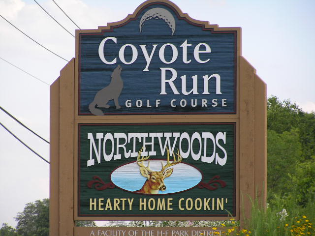 a sign for a golf course with a deer
