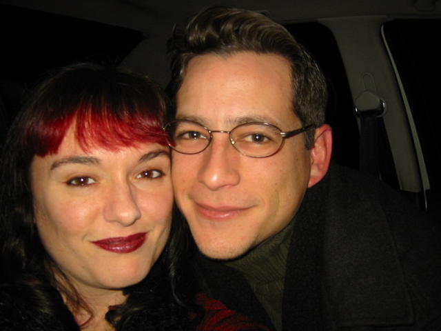 a man with eye glasses posing for a picture next to a woman