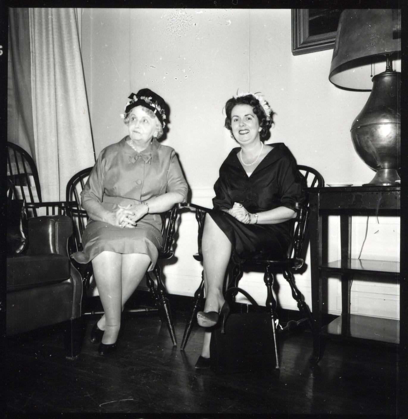 two women sitting in chairs talking to each other