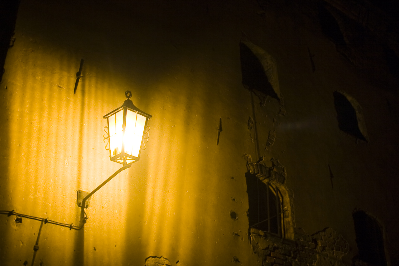 an old - fashioned street light is glowing in the dark