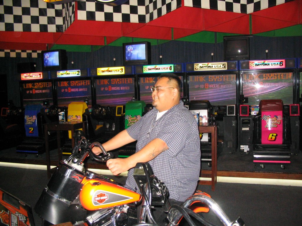 a man in glasses rides his motorcycle and smiles