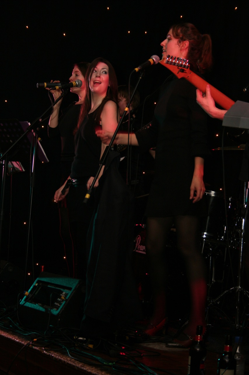 two women singing into microphones with music instruments