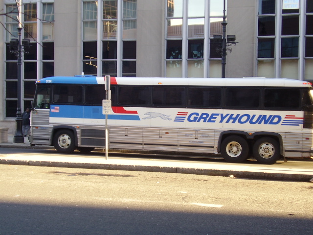 the greyhound bus is painted in blue, red, and silver