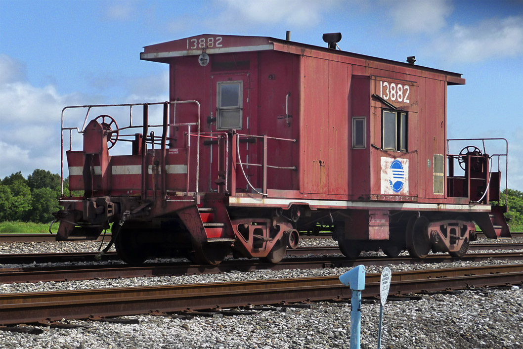 a caboose sits on a train track with other tracks nearby