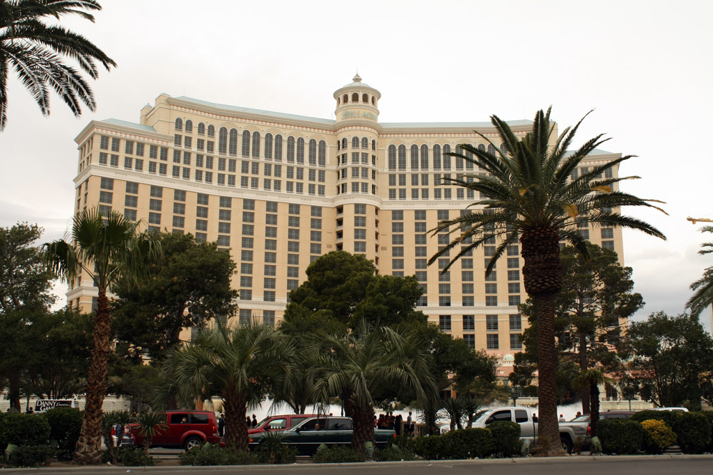 a el building surrounded by palm trees with a red truck parked in front