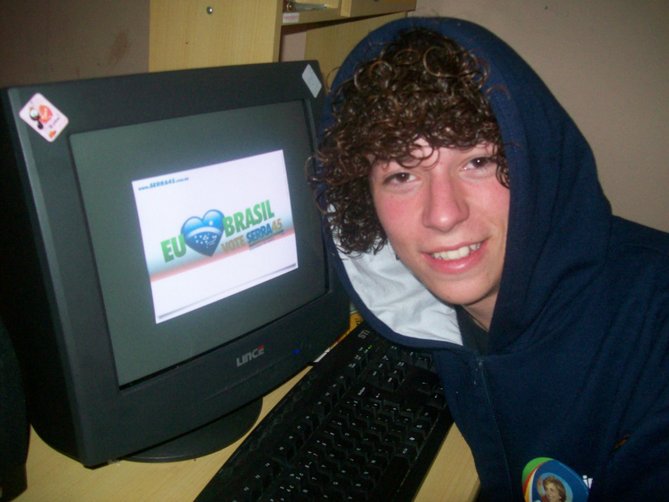 the man poses in front of an old computer