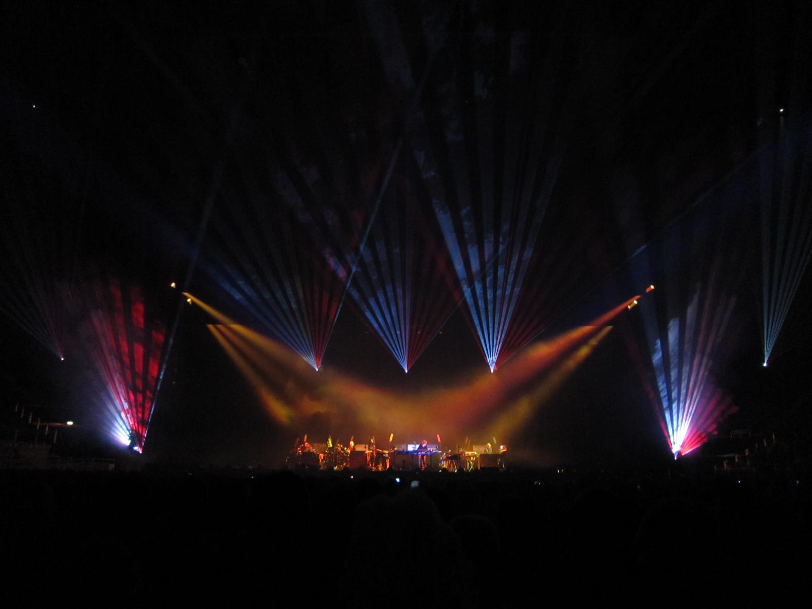 a concert with colorful lights in the dark