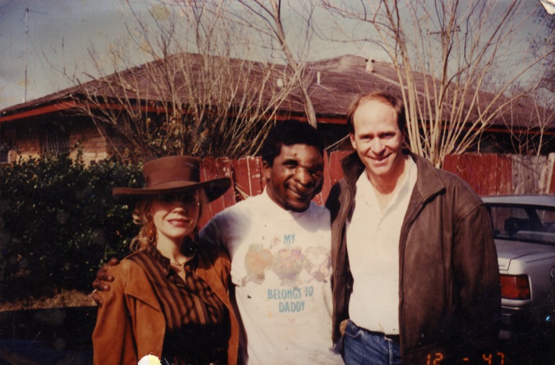 three men posing for a picture with a woman in front of some trees