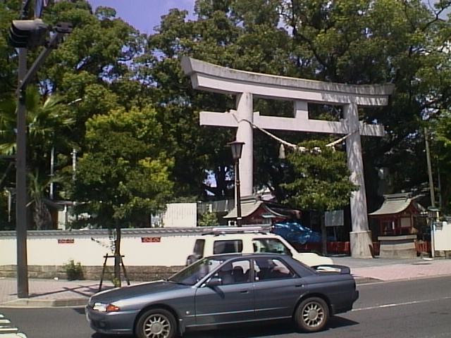 a car drives by a tall wooden gate