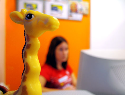 the giraffe toy has its mouth open as it stands in front of the woman