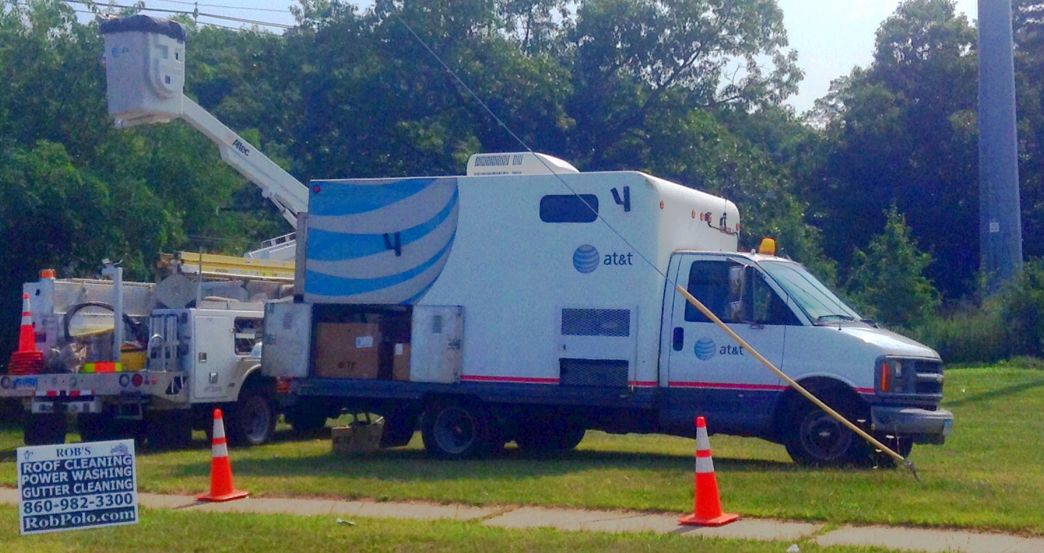 two street signs and trucks are parked on a grass field