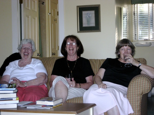 a group of women sitting on a brown couch