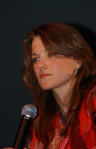 a young woman holding a microphone up to the camera