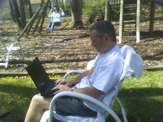 a man sitting in a white chair using his laptop