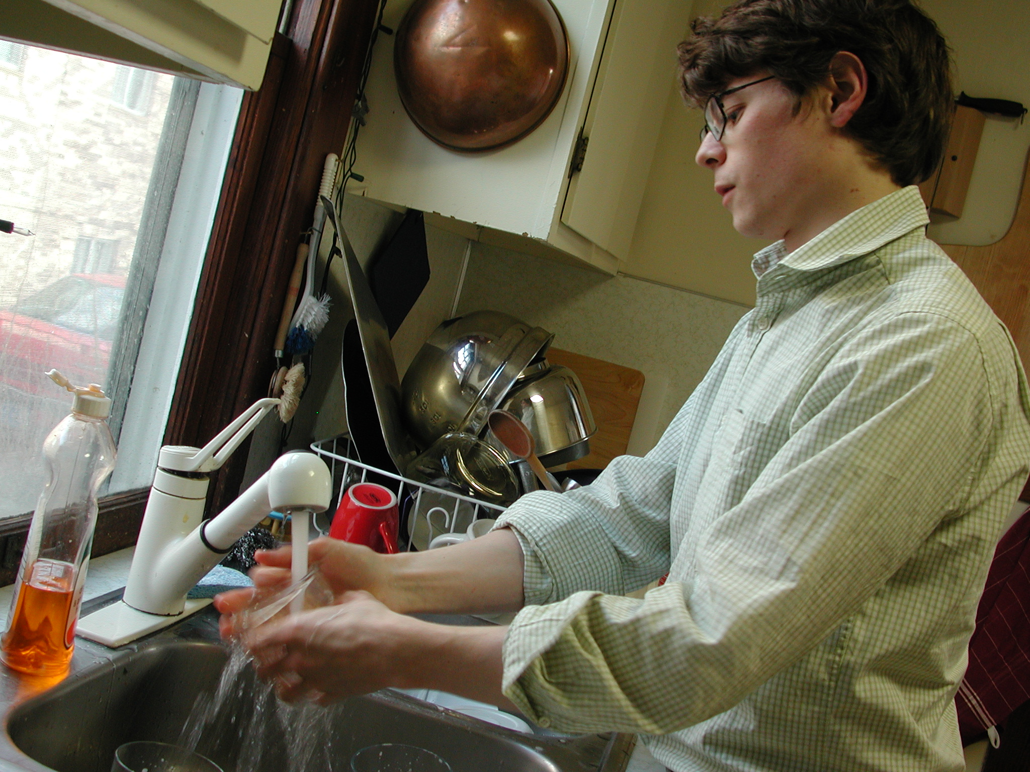 a person washing dishes in the kitchen sink