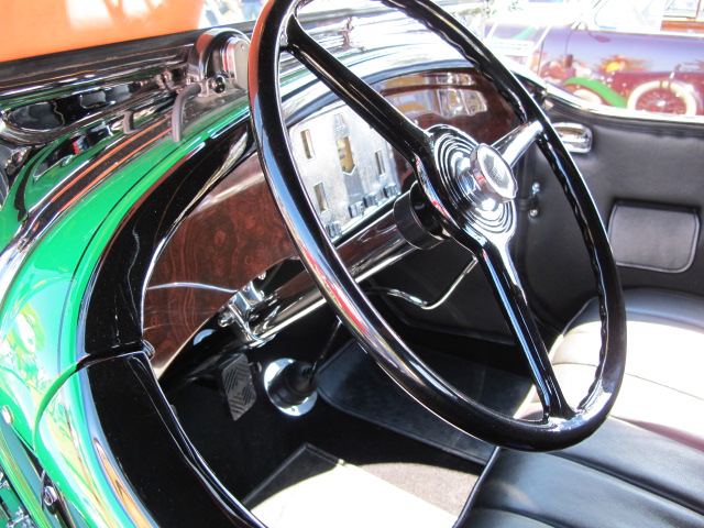 a green car dashboard with an old fashioned steering