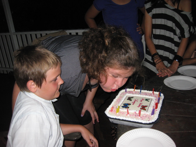 two children in front of a birthday cake