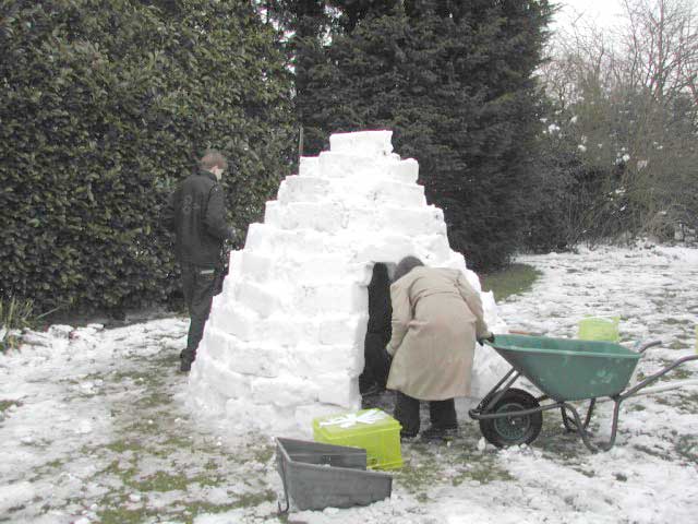 two men dig into a very tall snow sculpture