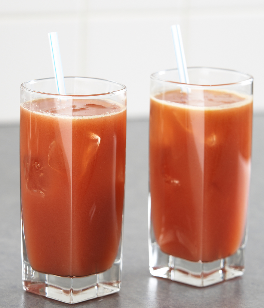 two glass of juice with two straws in them