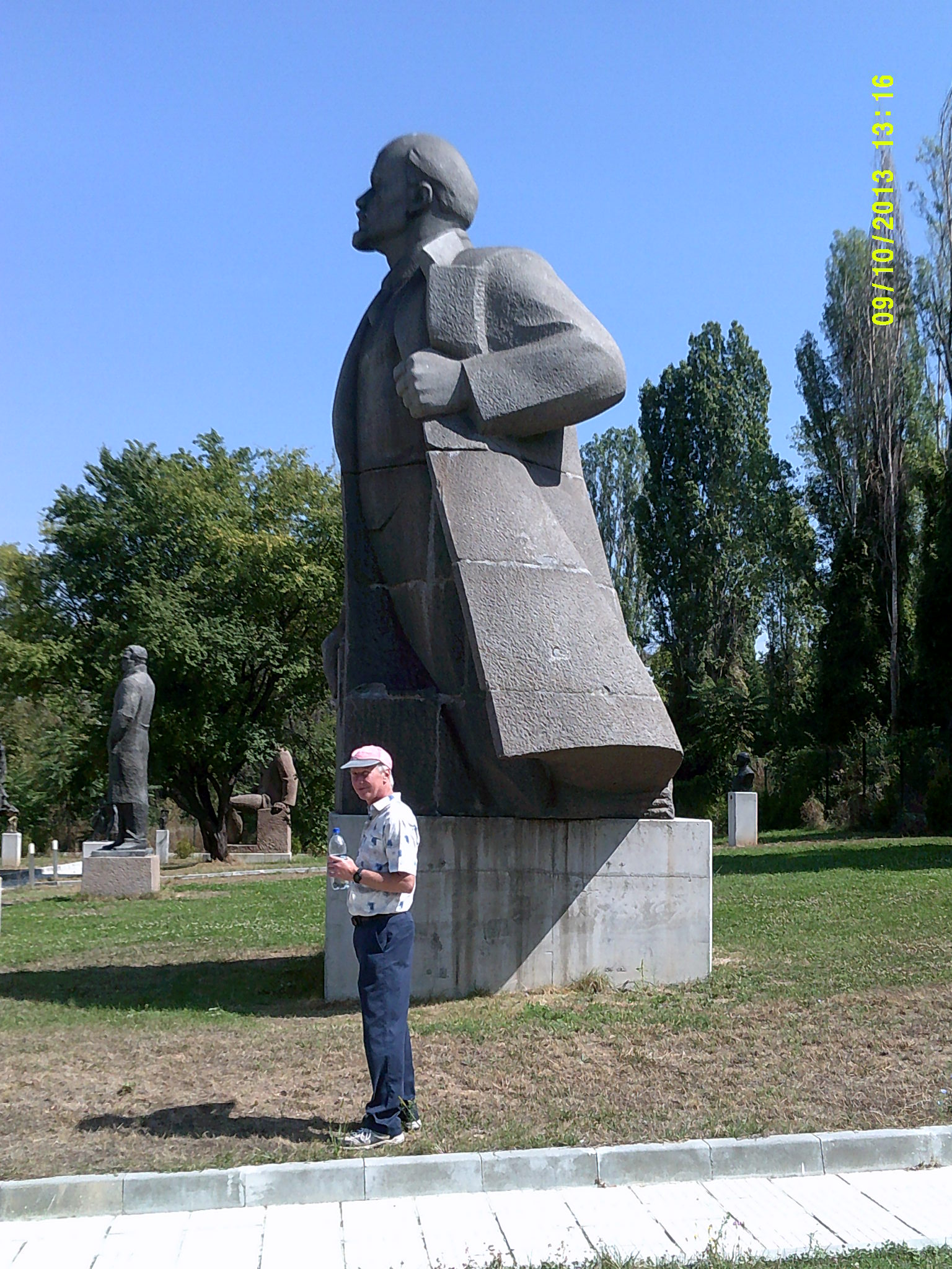 a person standing next to a statue of a man holding soing in his hand