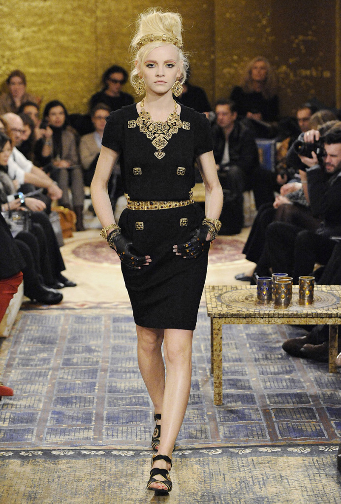the black dress has golden detailing and chains