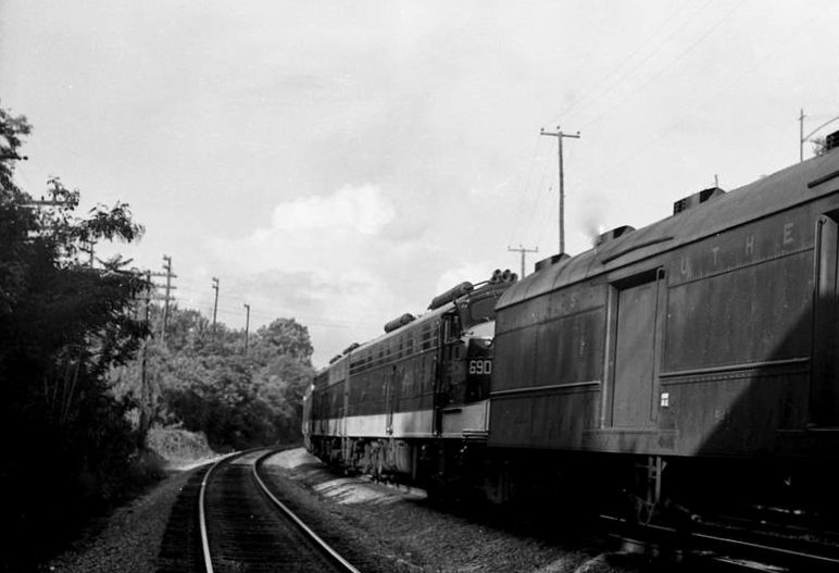 a black and white po of train tracks near trees