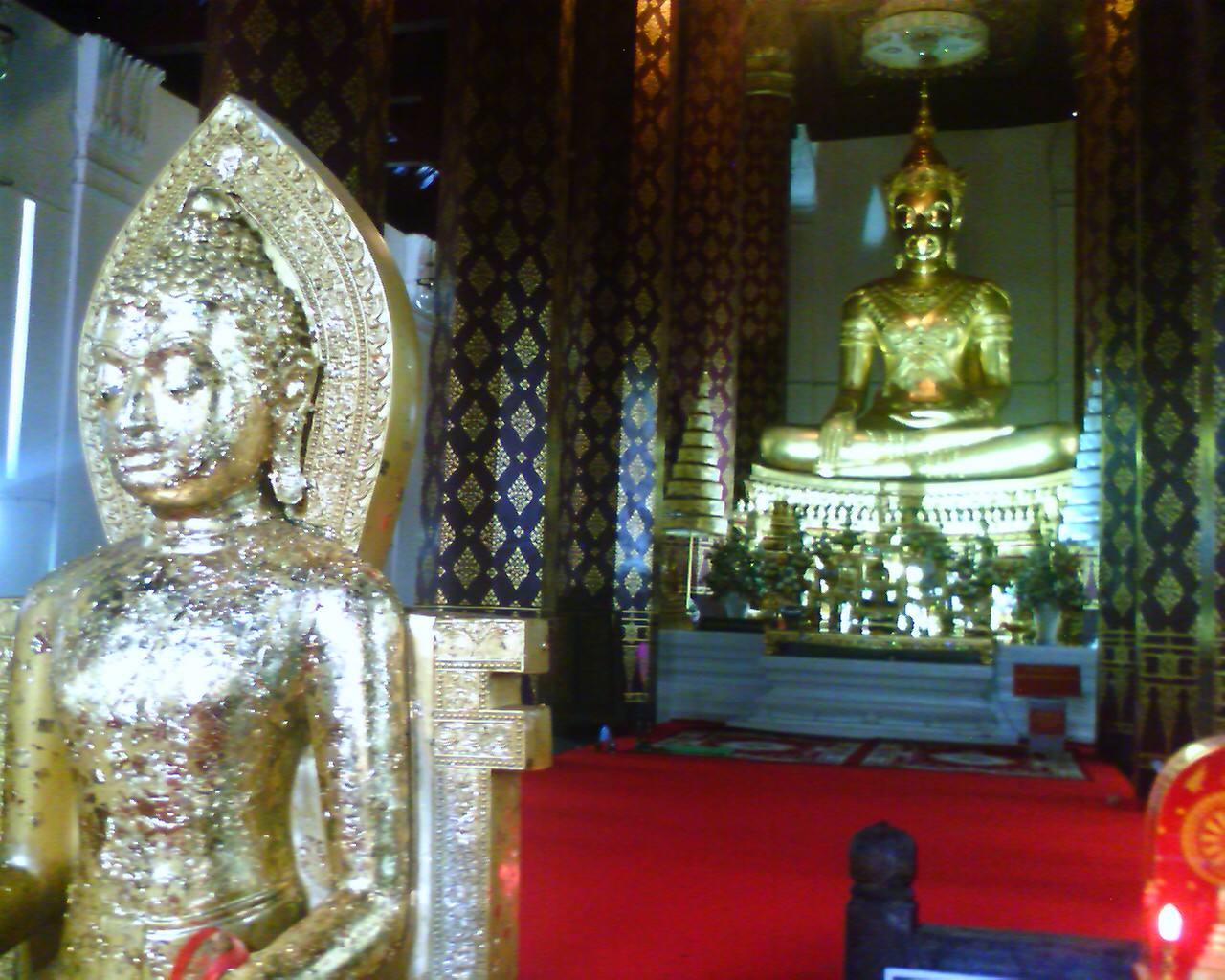 the buddha statue is surrounded by beautiful gold decorations