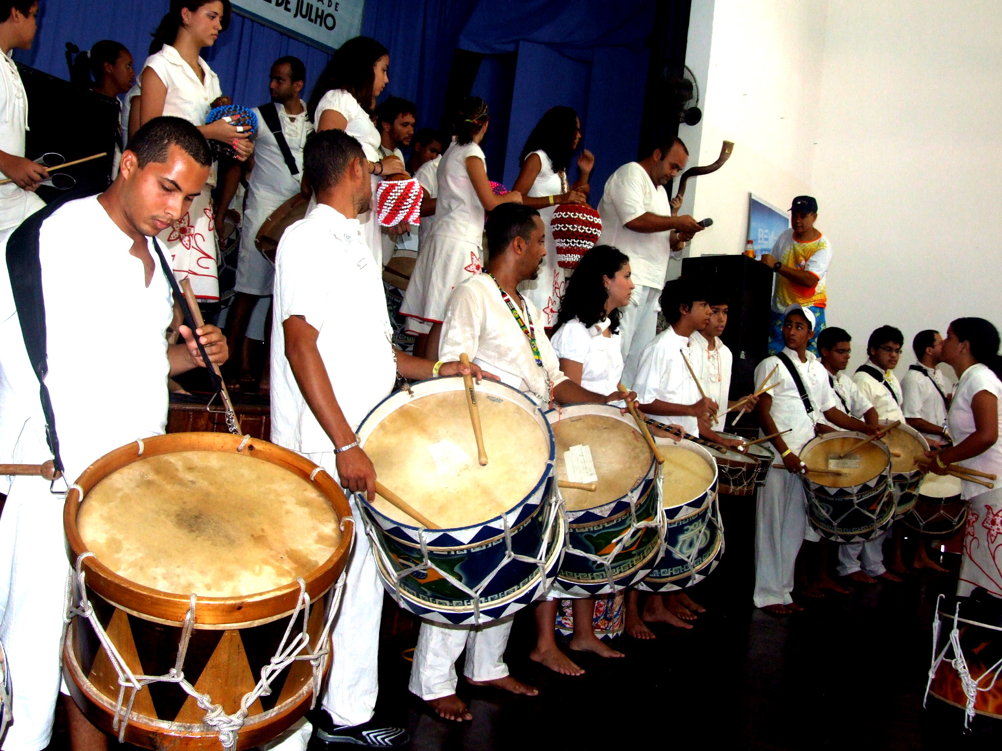 a group of people holding drums and standing next to each other