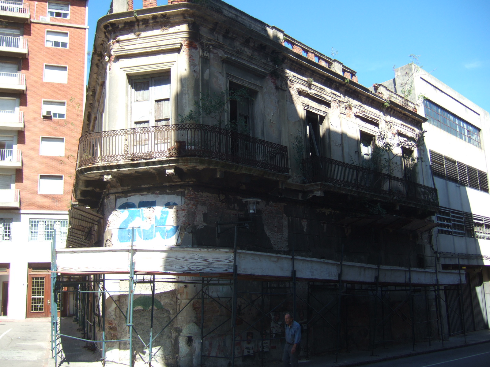 an old building in the street with balconies and graffiti on it