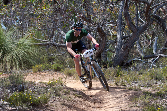 a male riding a mountain bike on a dirt trail