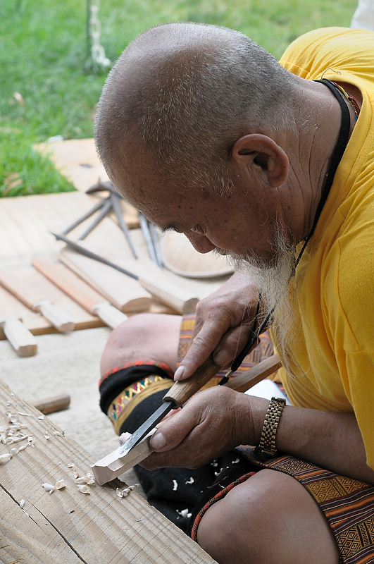 man  and making wooden object with small tools