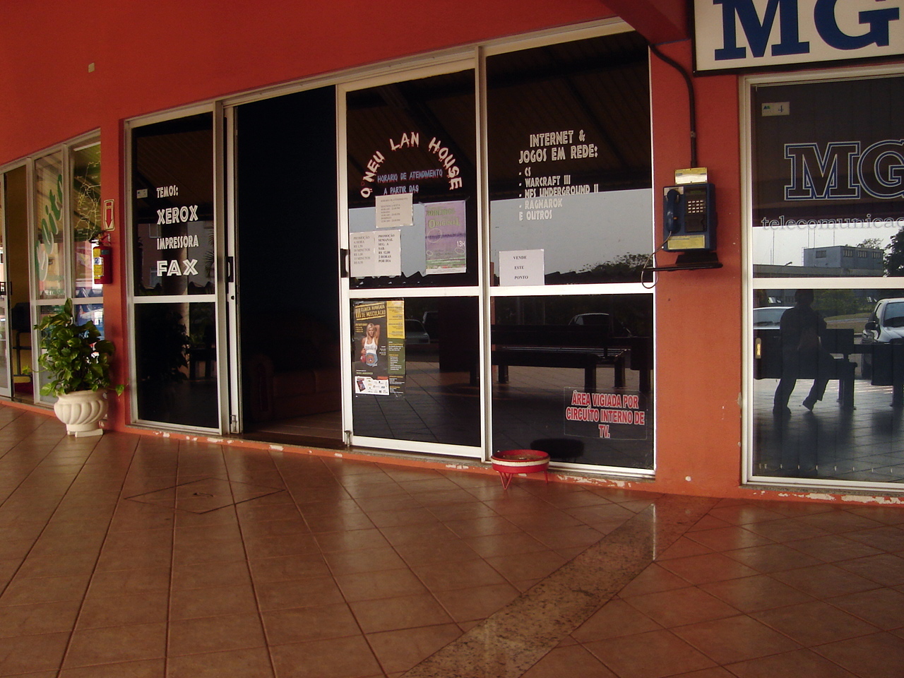 the front windows of a store with signs advertising business