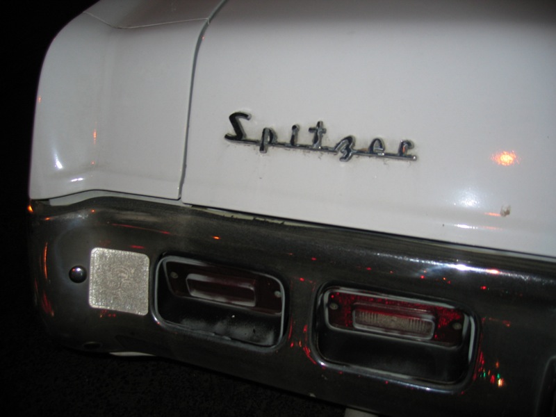 the back end of a white car with black letters