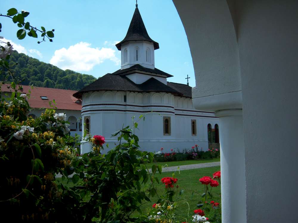 white church in country setting behind a flowered archway