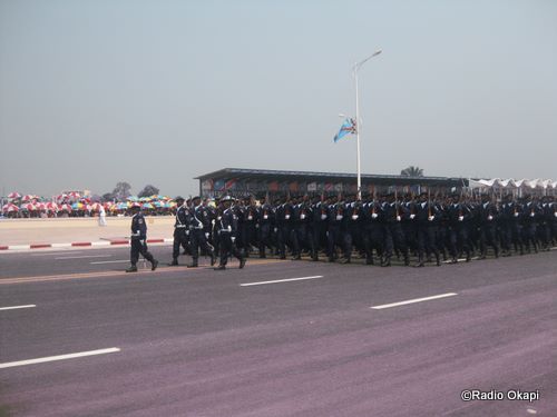 a line of uniformed men are marching down a street