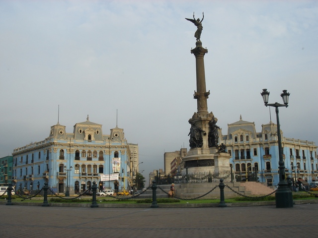 a monument on the city plaza in front of buildings