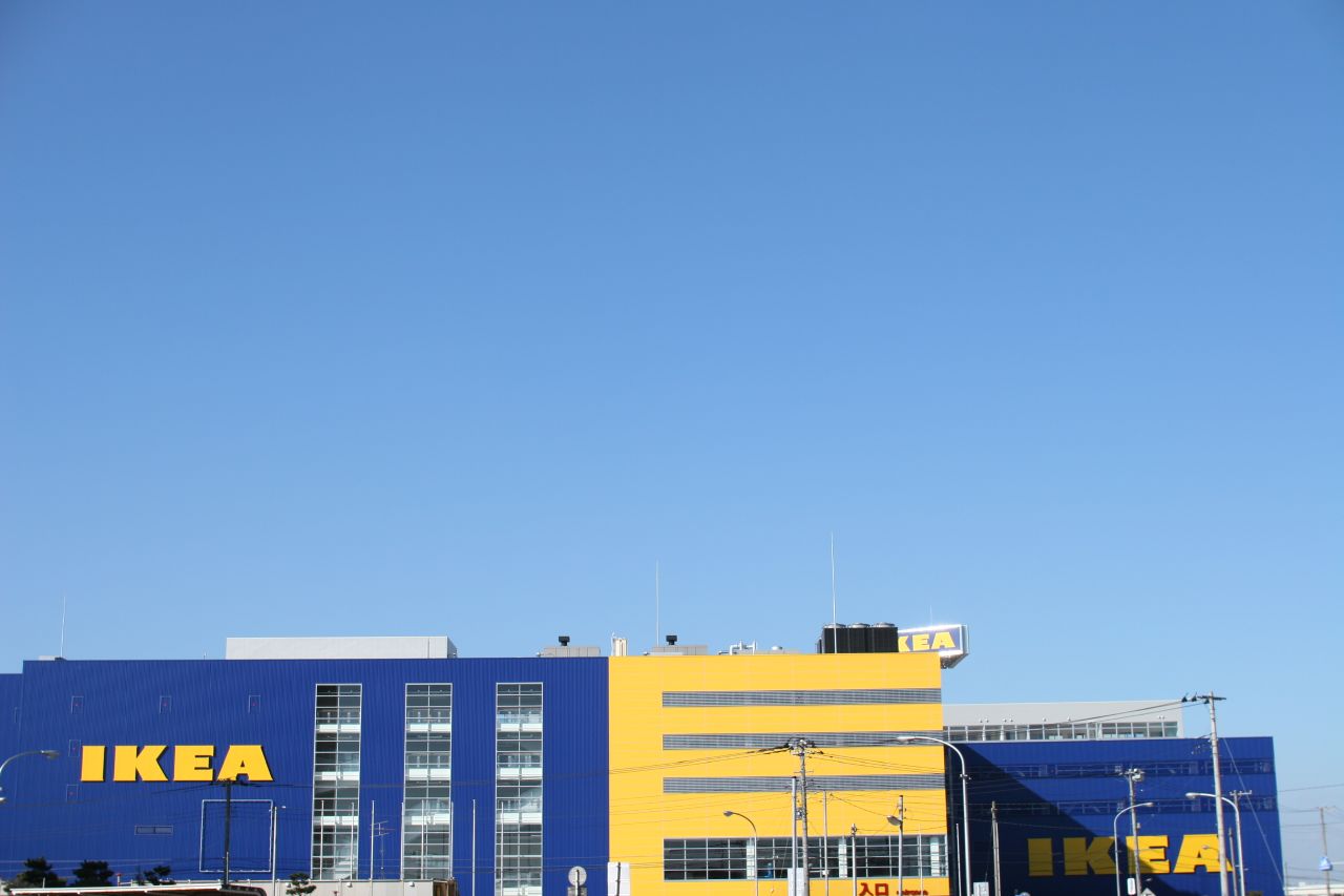 a yellow and blue ikea building with cars outside