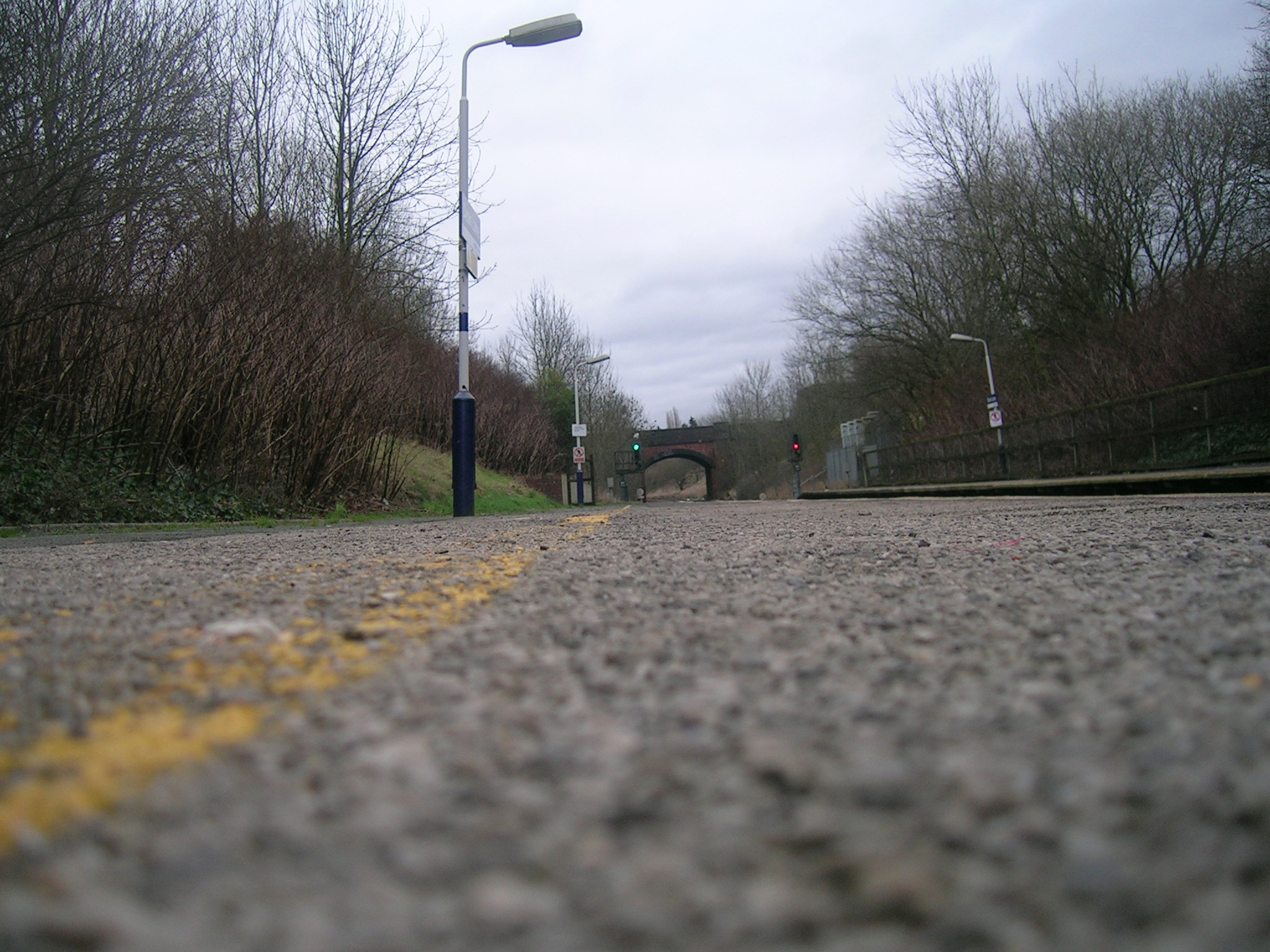 an empty road with yellow line and light posts