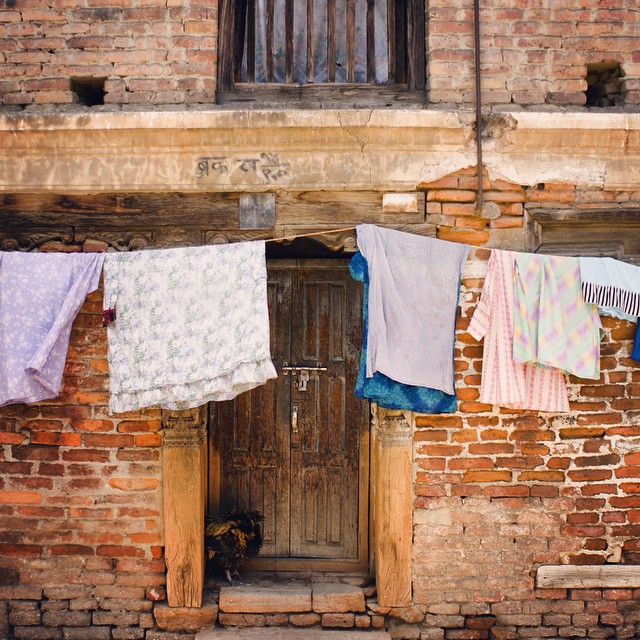 three towels on clothes line in front of a brick building
