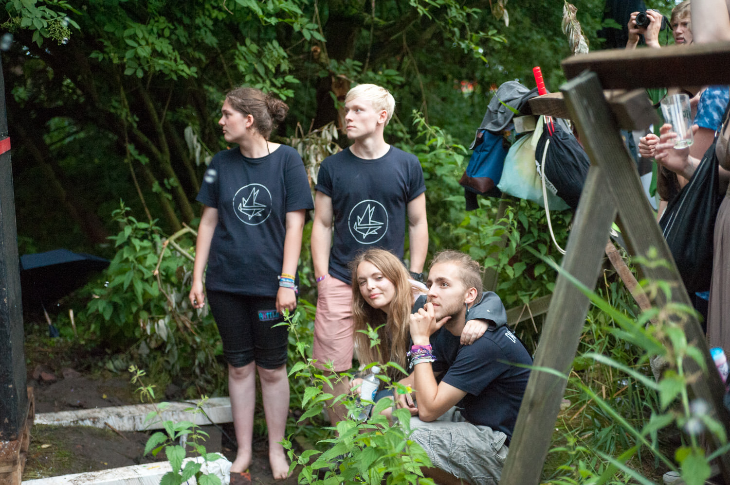 several people are standing on a platform surrounded by some plants